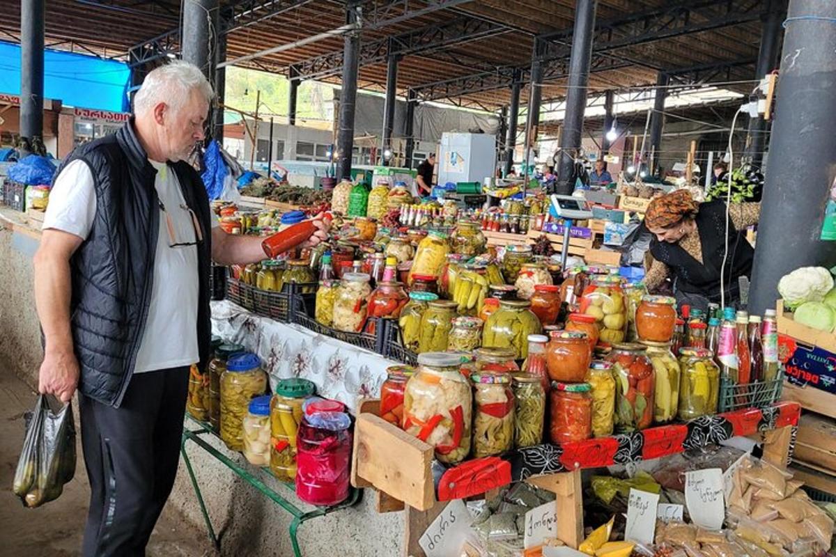 Egy idősebb férfi áll egy kirakat előtt a piacon