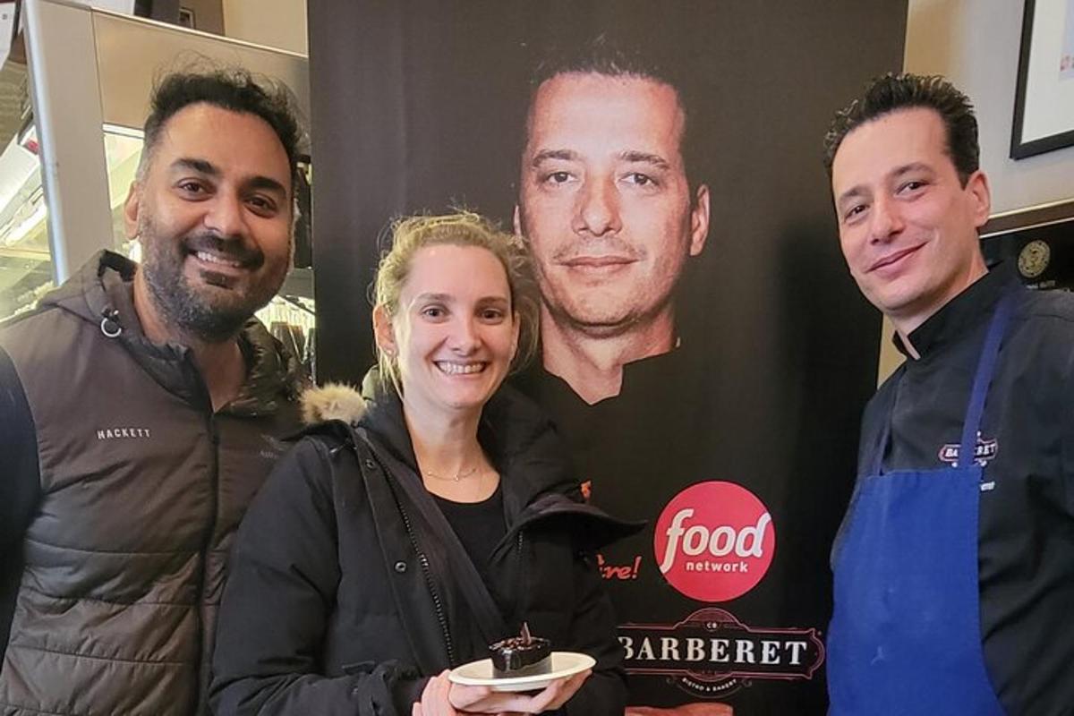 a woman standing next to two men holding a plate of food