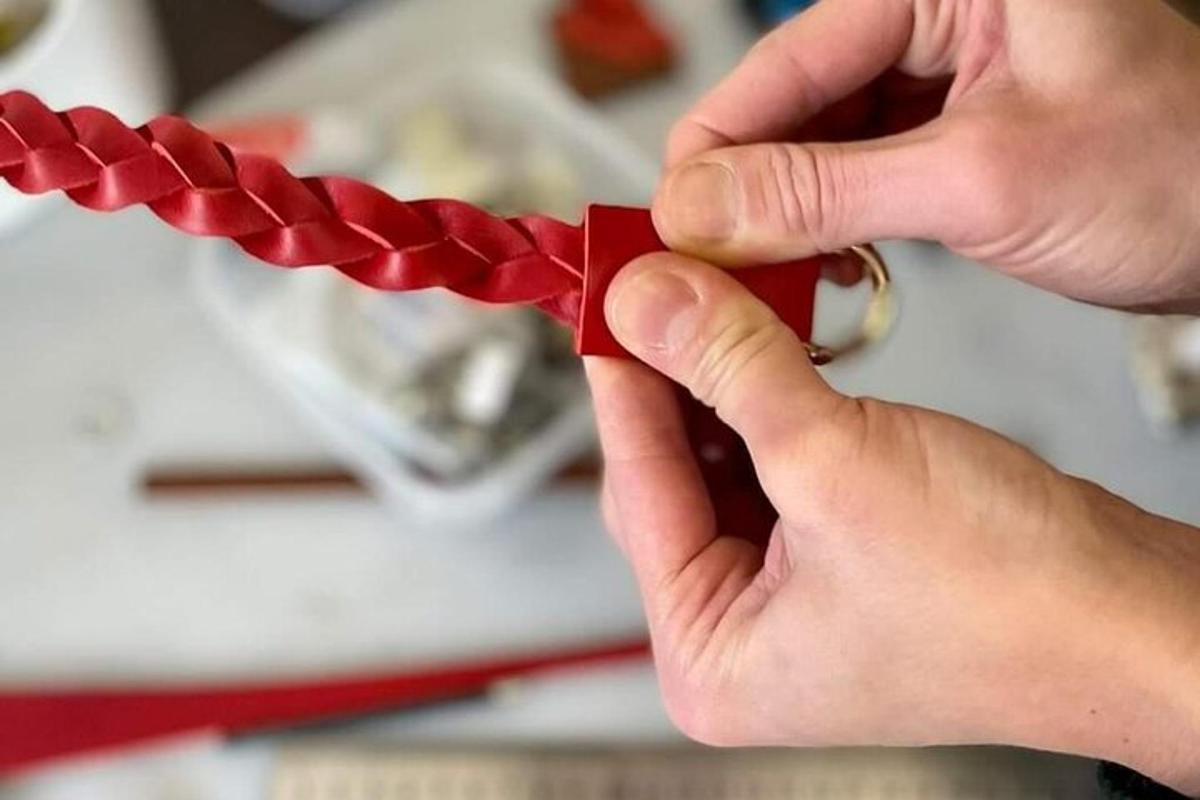 eine Person, die ein Stück rotes Papier zusammenbindet