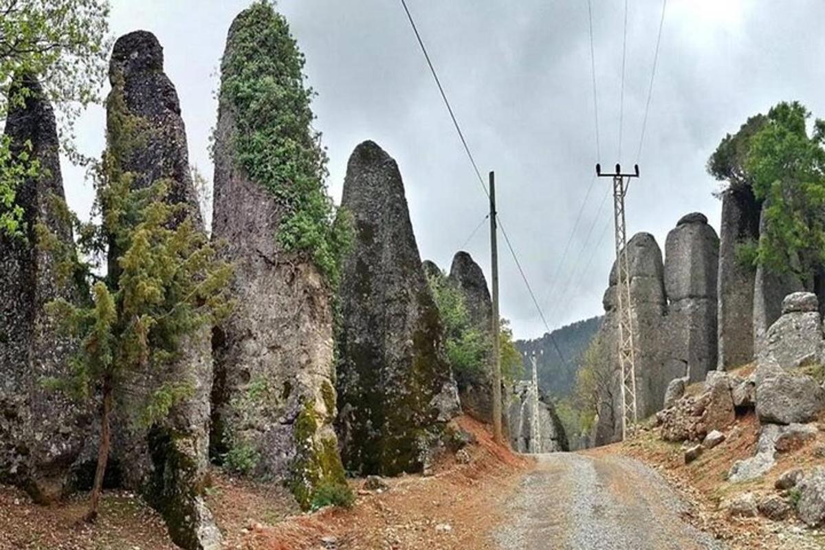 prašná cesta s veľkými skalnými útvarmi na hore