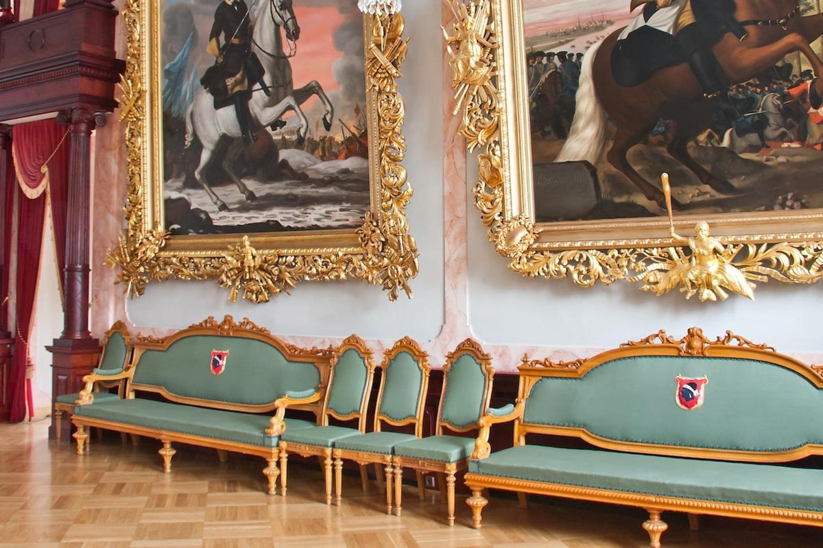 a room with two chairs and paintings on the wall