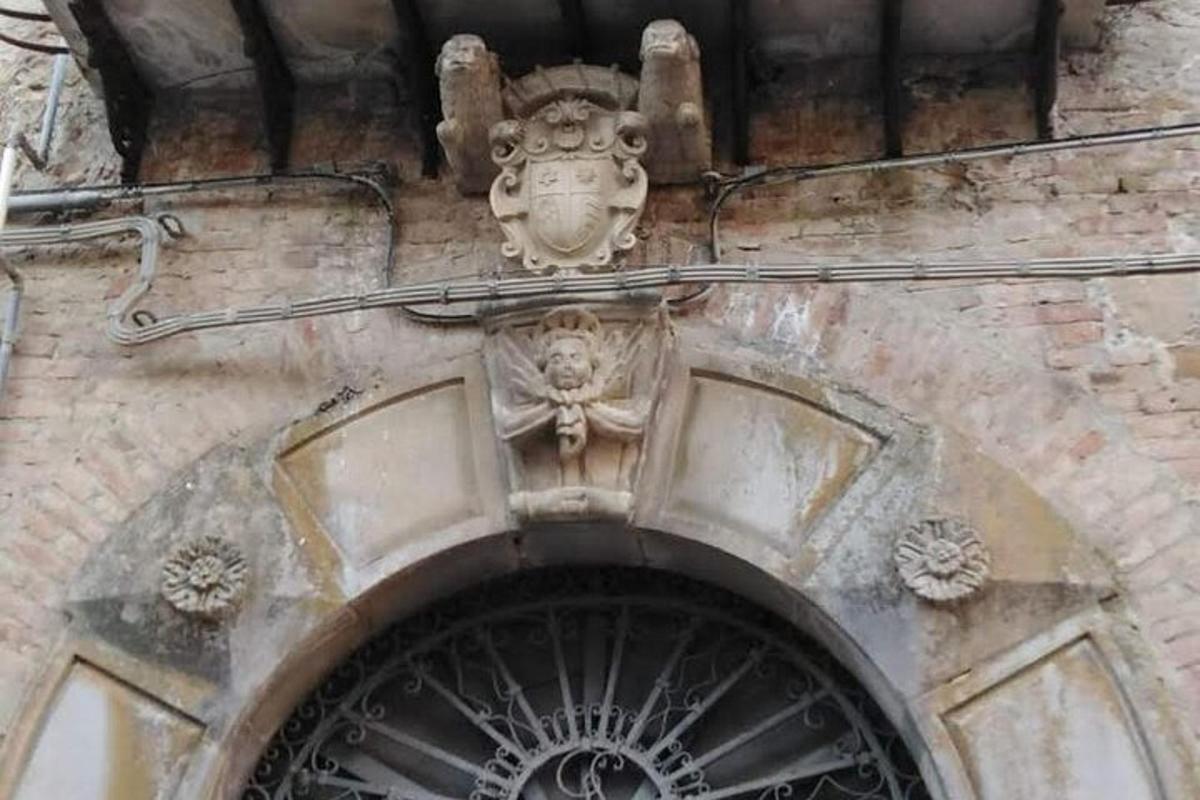 Una entrada a un edificio con una estatua sobre una puerta.