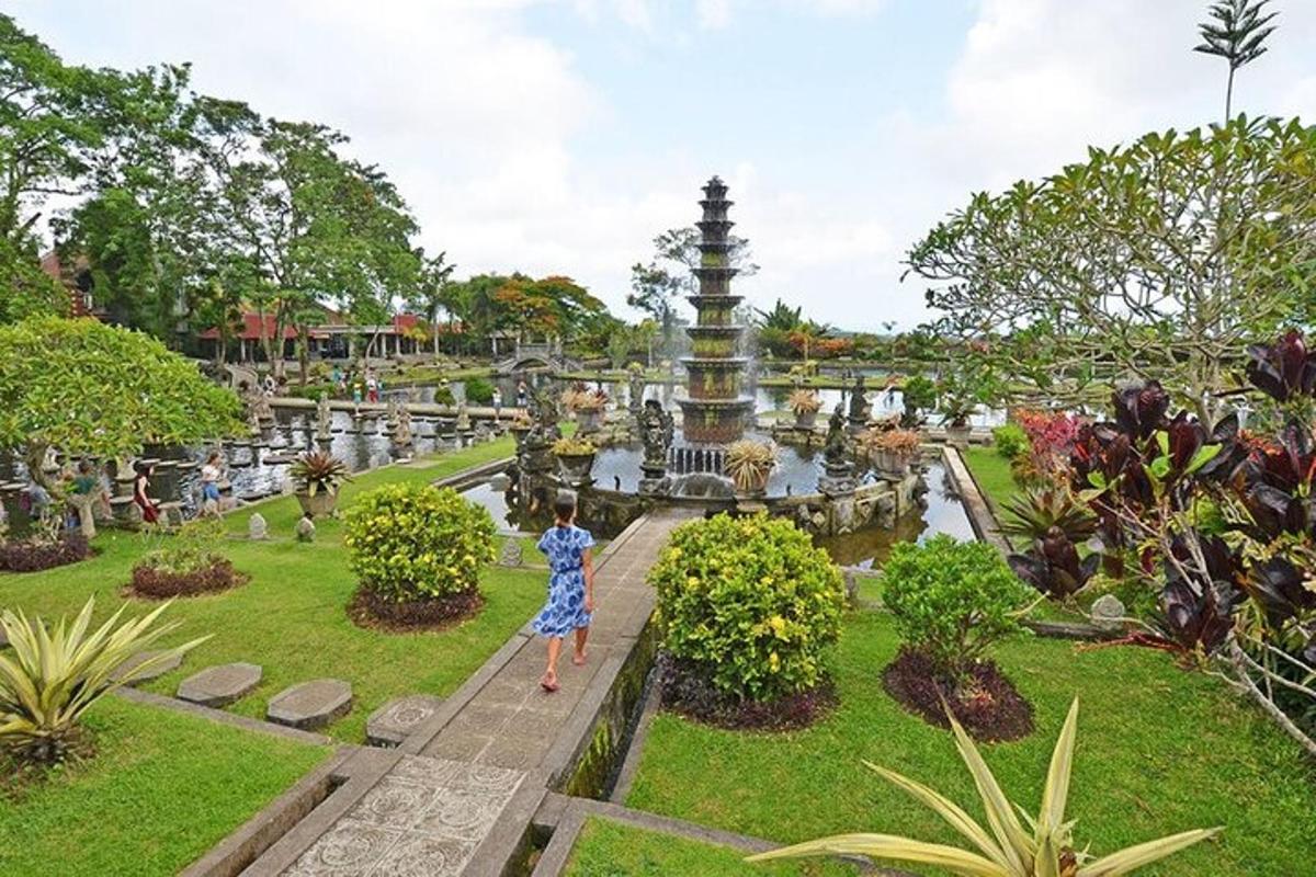 một người phụ nữ đứng trước đài phun nước trong công viên