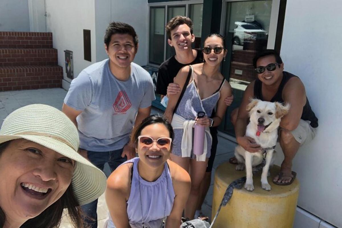 um grupo de pessoas posando para uma foto com um cachorro