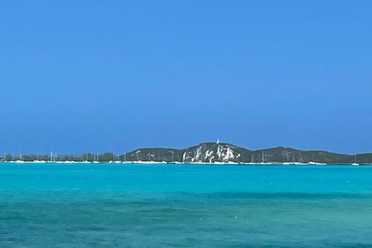 a large body of blue water with mountains in the background