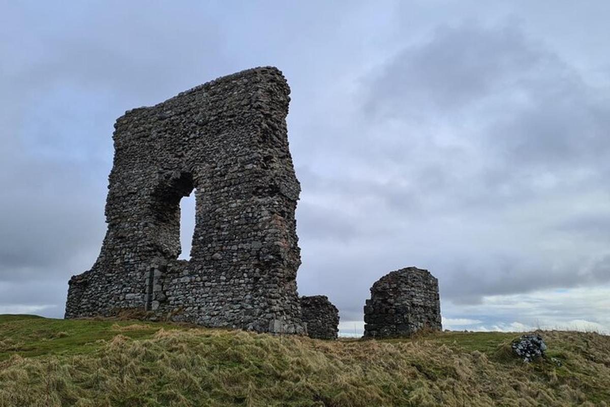 un vecchio castello in cima a una collina erbosa