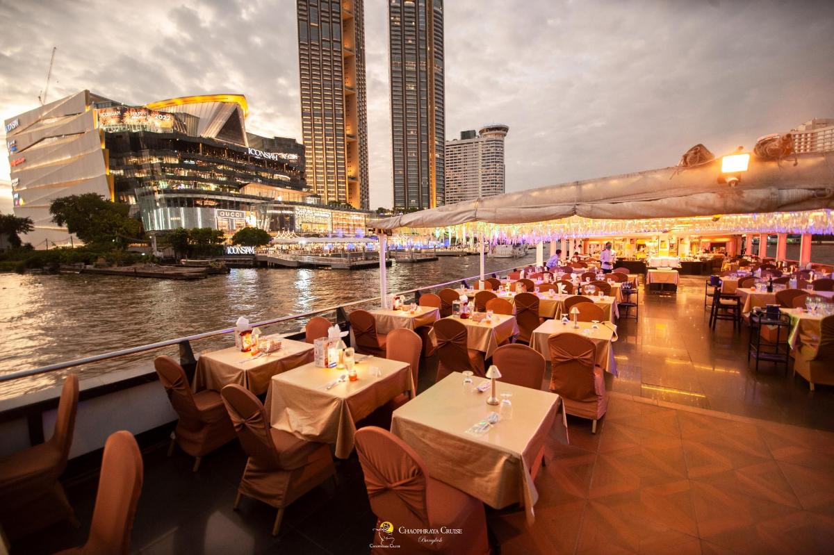 a restaurant with tables and chairs next to a river