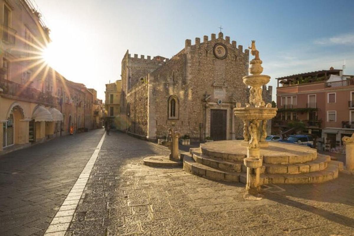 un vecchio edificio con una fontana in mezzo a una strada