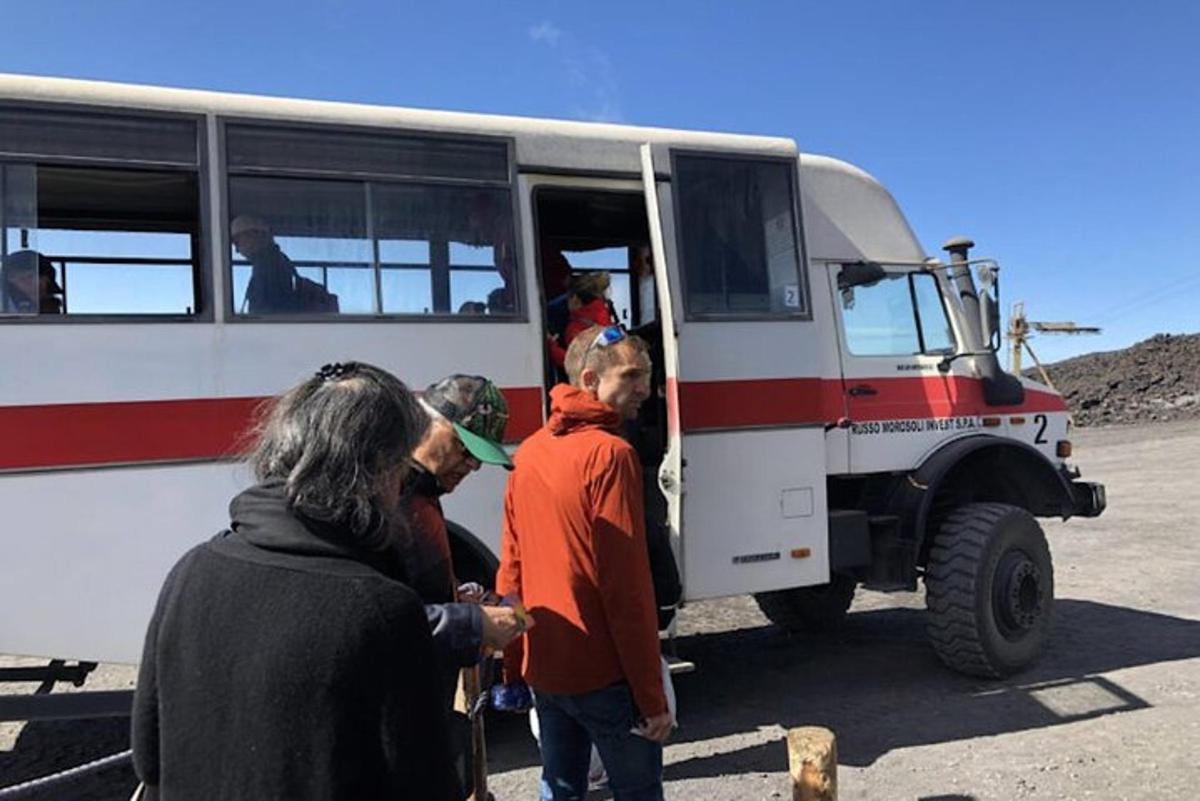 en gruppe mennesker som står utenfor en buss