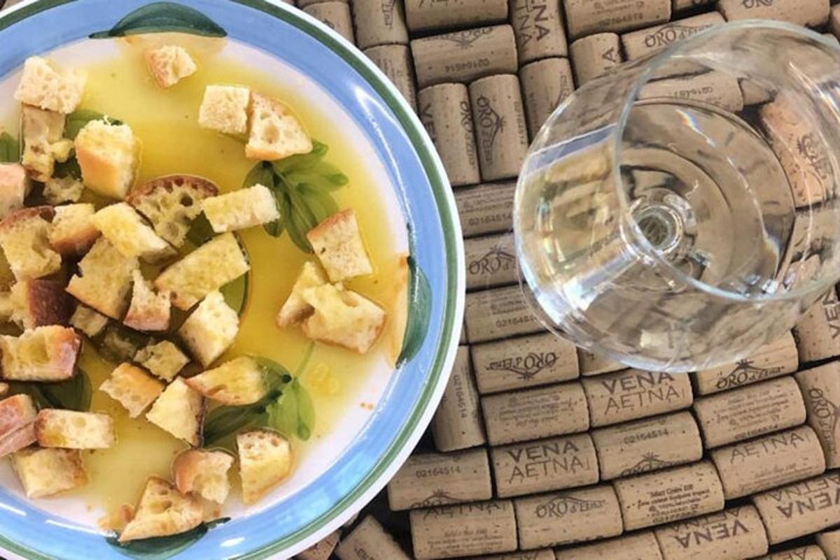 uma tigela de sopa ao lado de uma taça de vinho