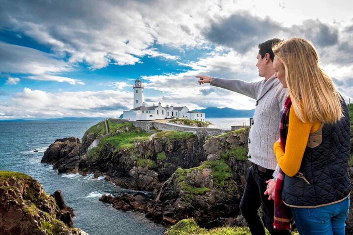 a man and a woman looking at a lighthouse