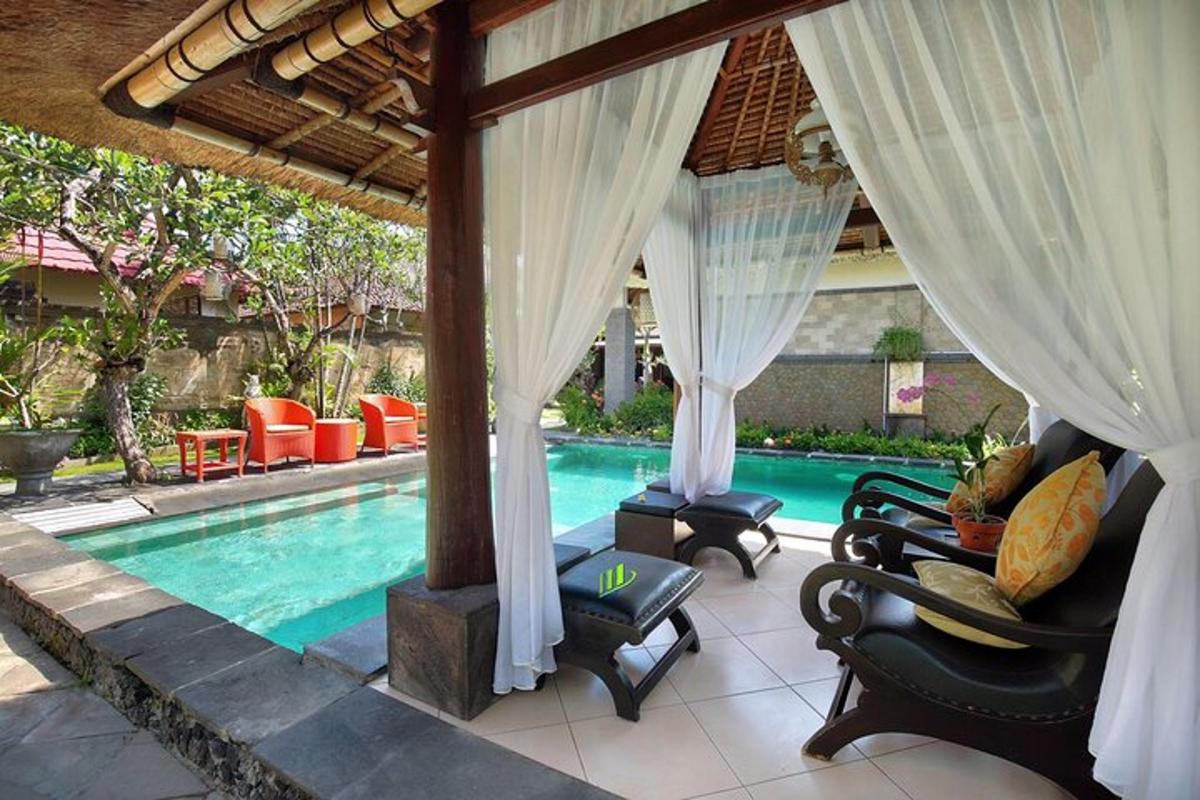 a swimming pool with chairs and a pavilion next to a resort