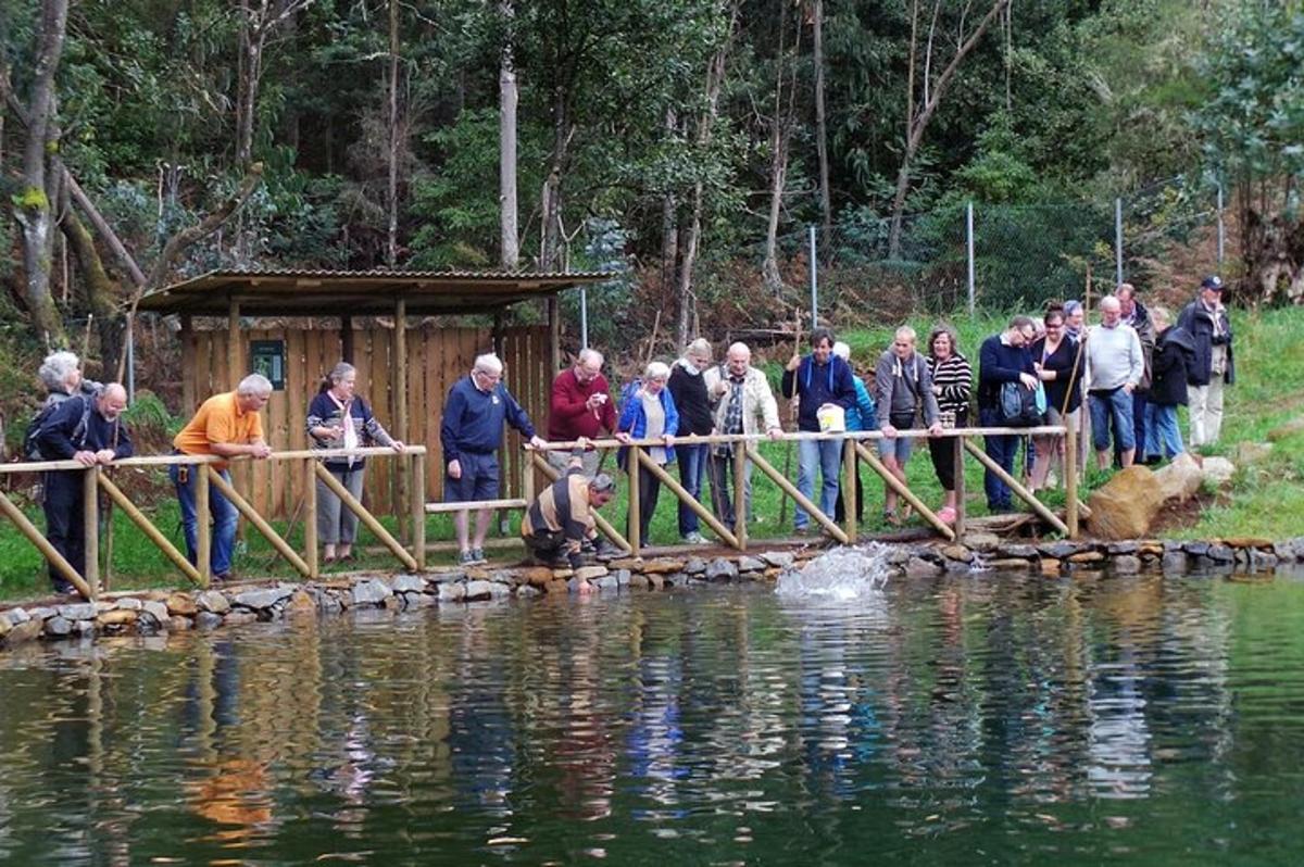 un gruppo di persone in piedi su un ponte sopra uno specchio d'acqua