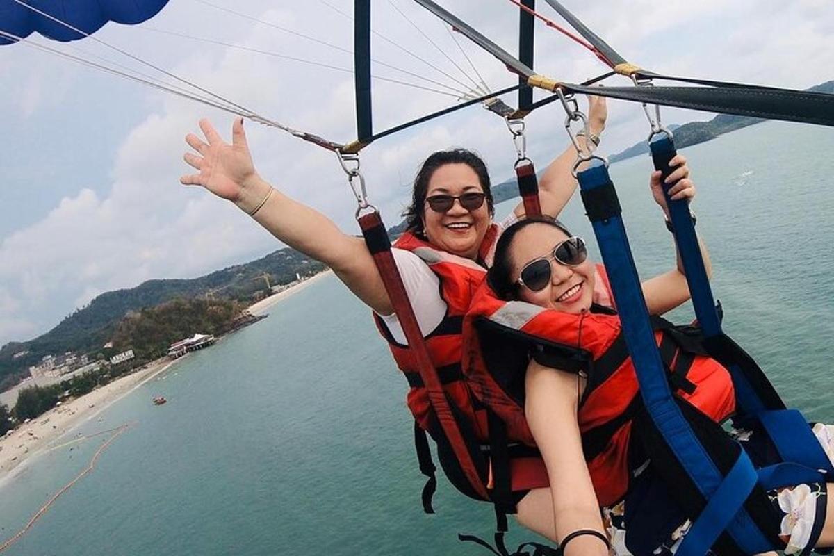 dva lidé jedou na zipline nad vodou