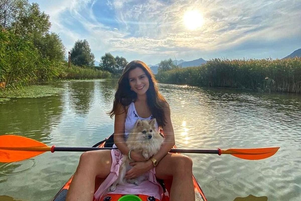 a girl and a dog in a kayak on a river