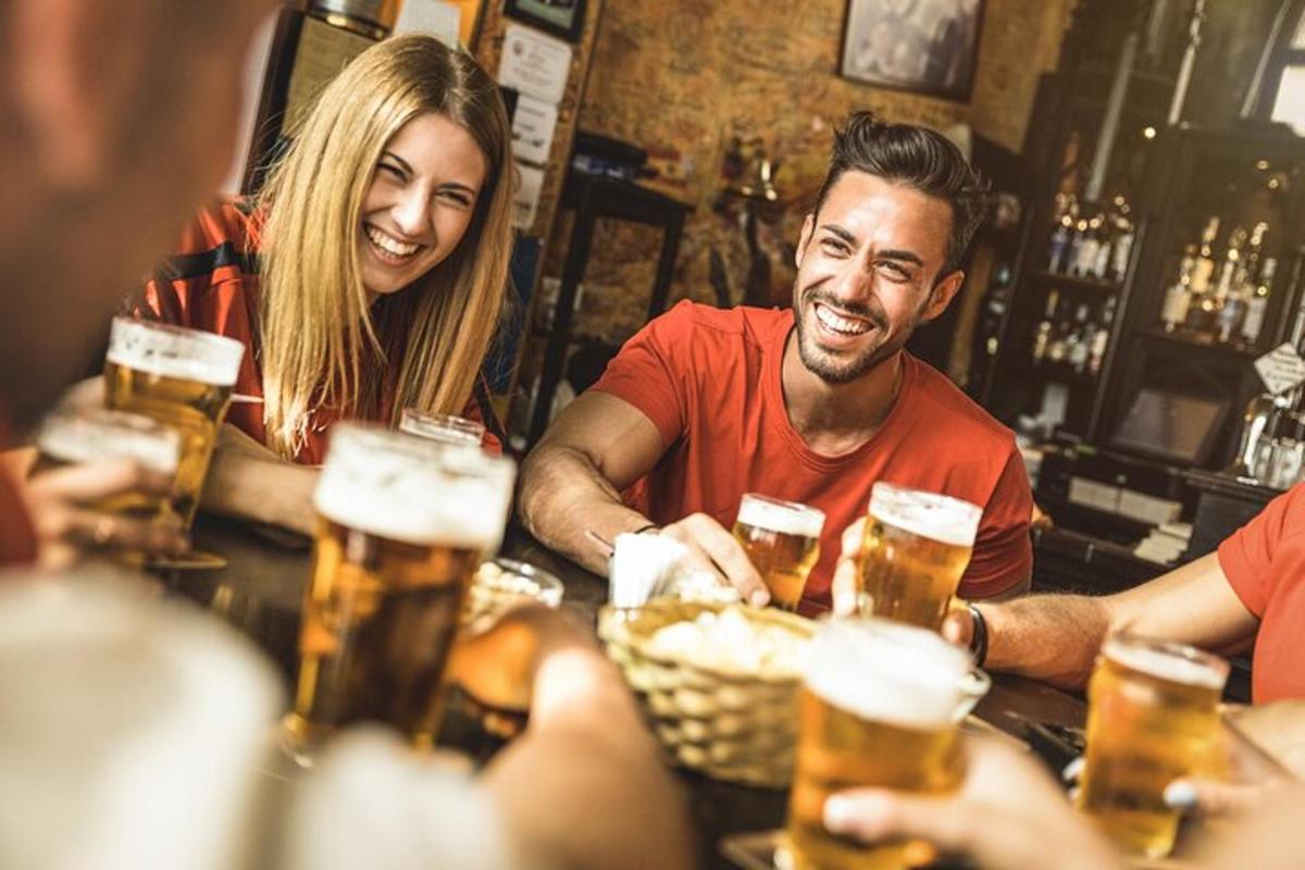 skupina lidí sedících u baru a pijících pivo