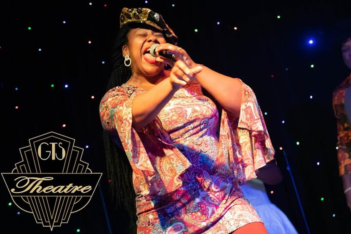 a woman singing into a microphone on a stage
