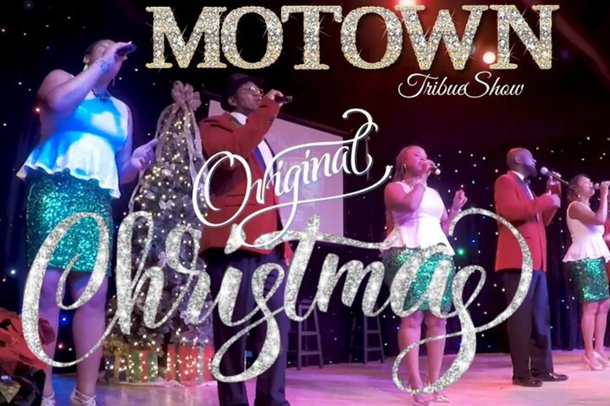 a group of people on a stage with a merry christmas sign