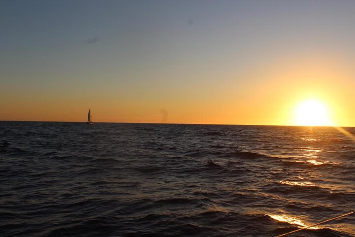 una barca a vela nell'oceano al tramonto