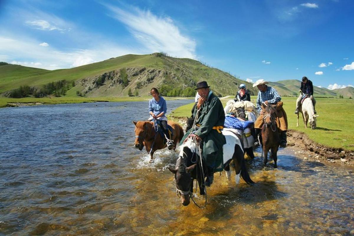 a group of people riding horses in the water