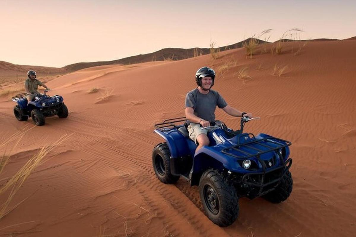 dois homens andando de quadriciclo no deserto