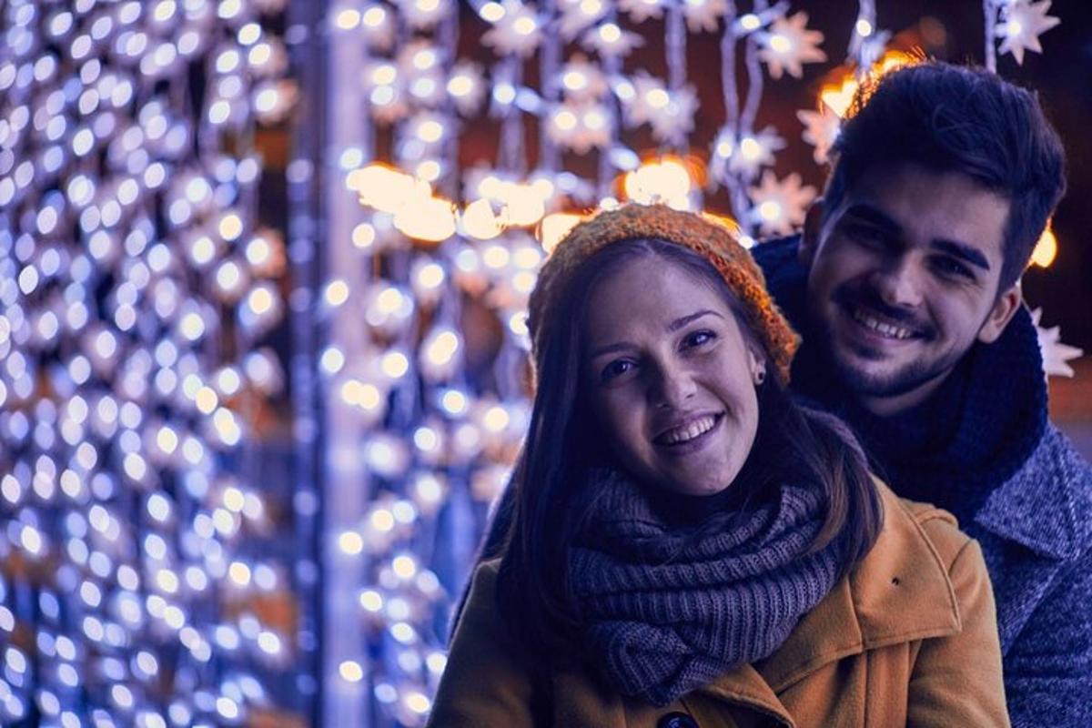Egy férfi és egy nő karácsonyi fények előtt állva