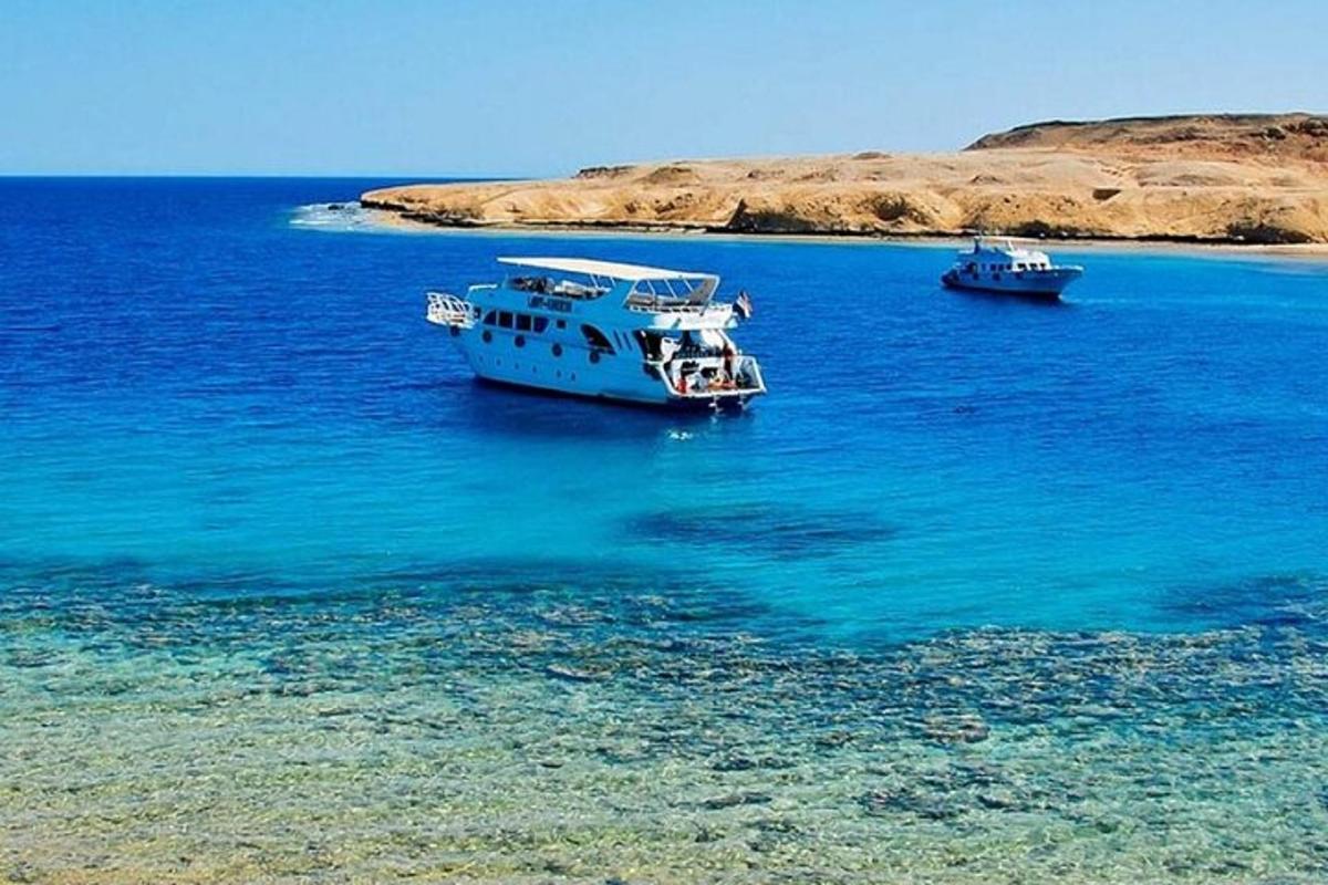 due barche che galleggiano nell'acqua vicino a una spiaggia