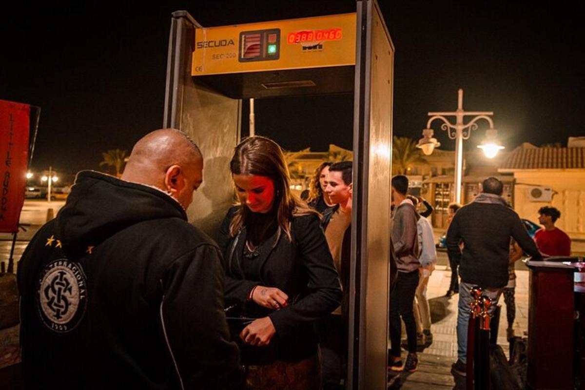 un uomo e una donna in piedi davanti a una pompa di benzina