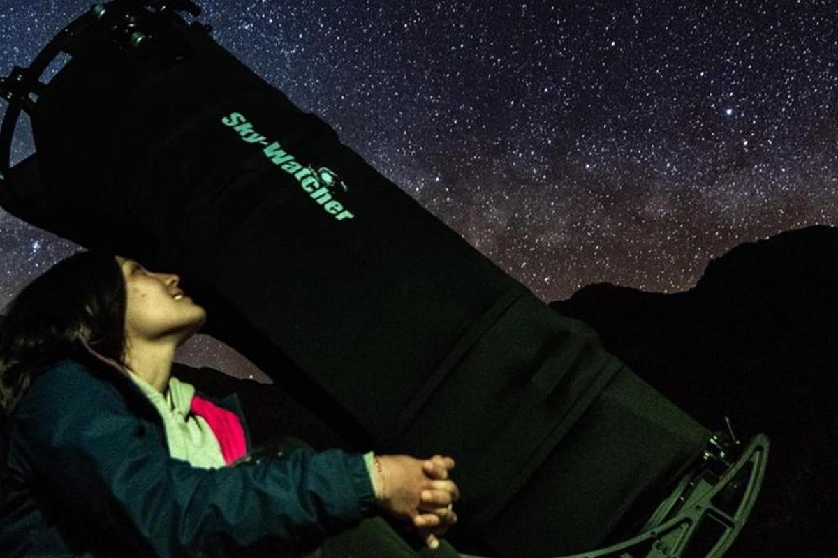 a woman is looking up at the night sky