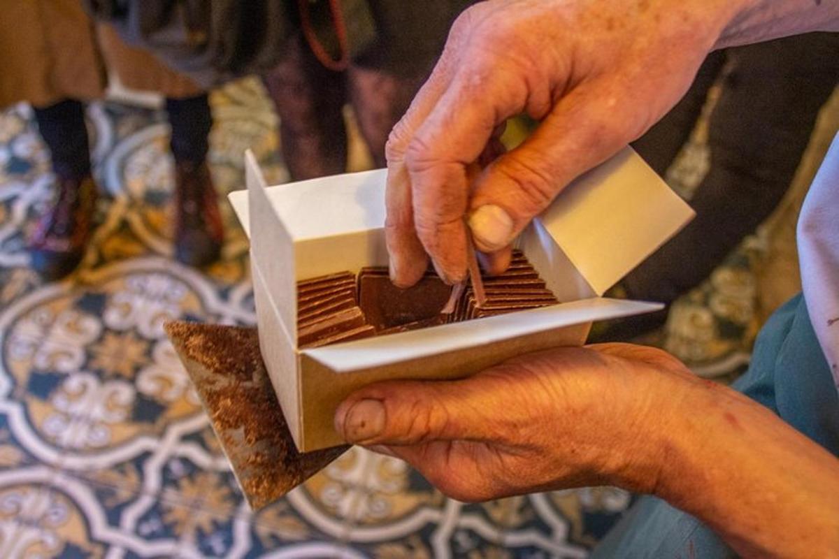 a person holding a piece of food in a box
