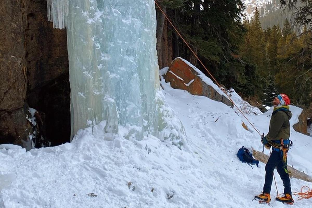 a person is standing next to a frozen waterfall