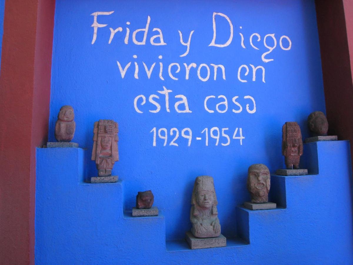 Una exhibición de estatuas antiguas en una pared azul.