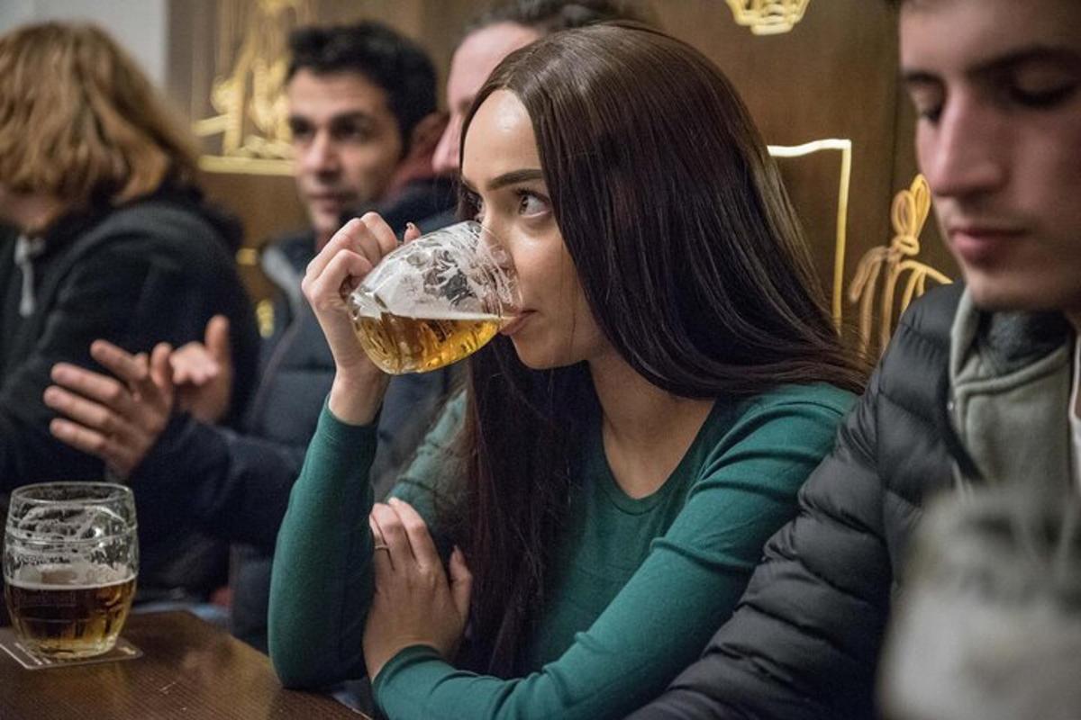 žena pije sklenici piva u stolu