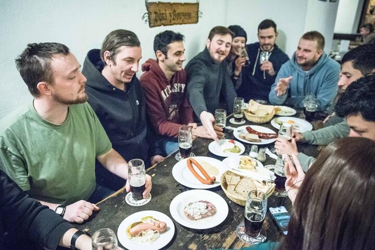 skupina lidí sedících kolem stolu a jedících jídlo