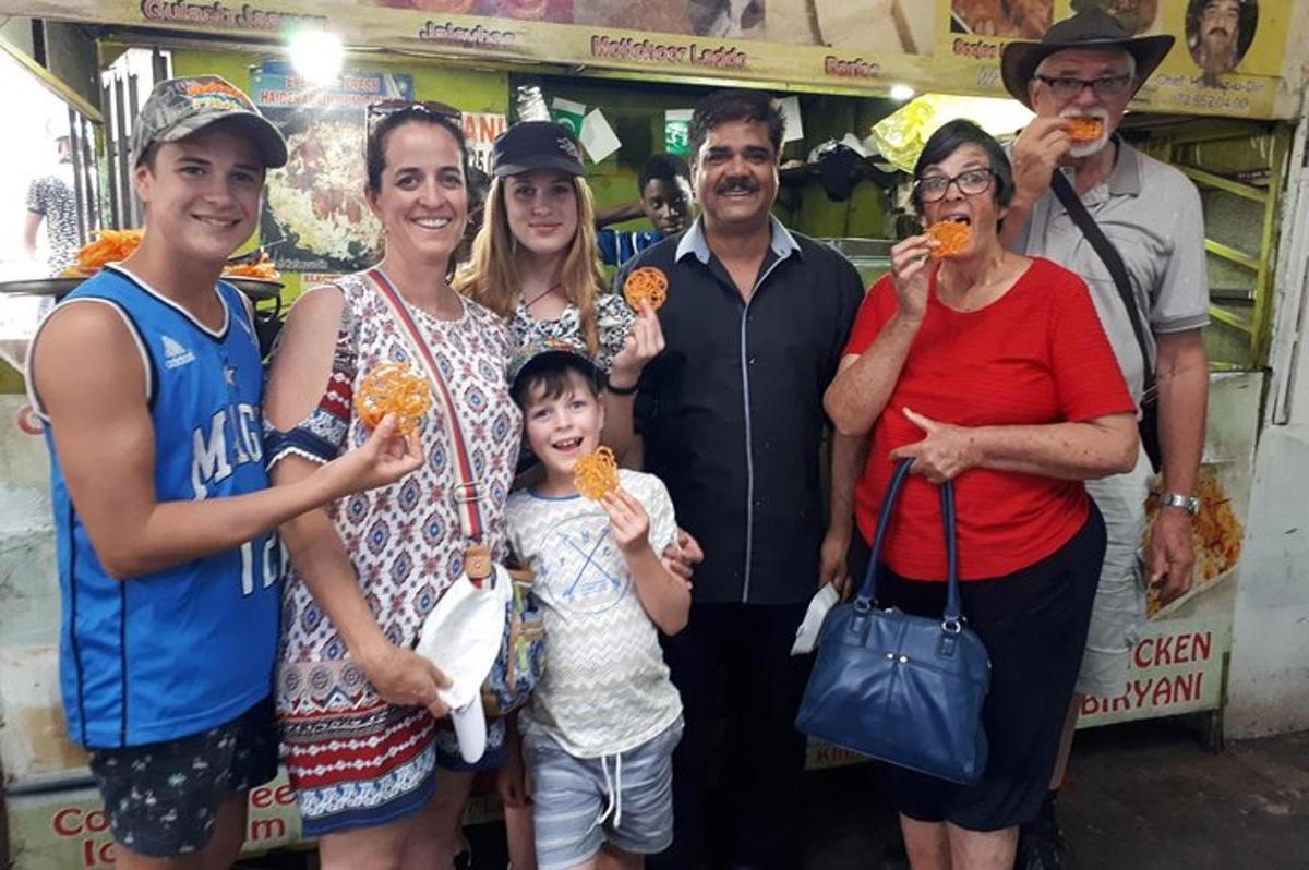 Un grupo de personas posando para una foto mientras comen comida.
