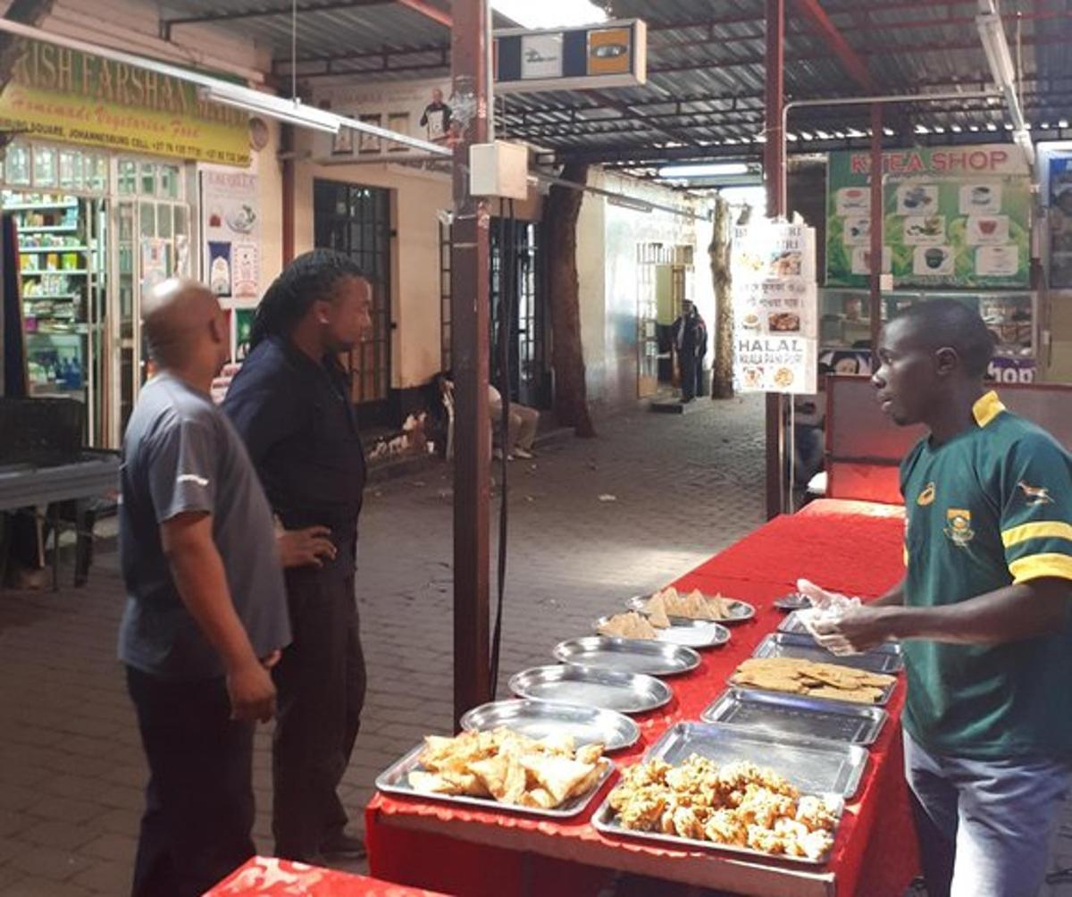 sekumpulan lelaki berdiri di sekeliling meja dengan makanan