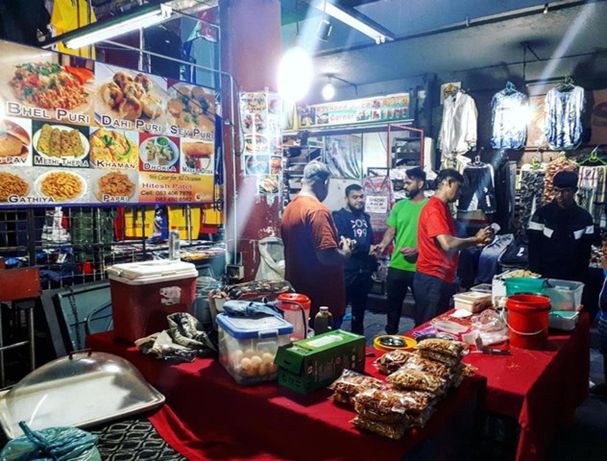 sekumpulan orang berdiri di sekeliling gerai makanan