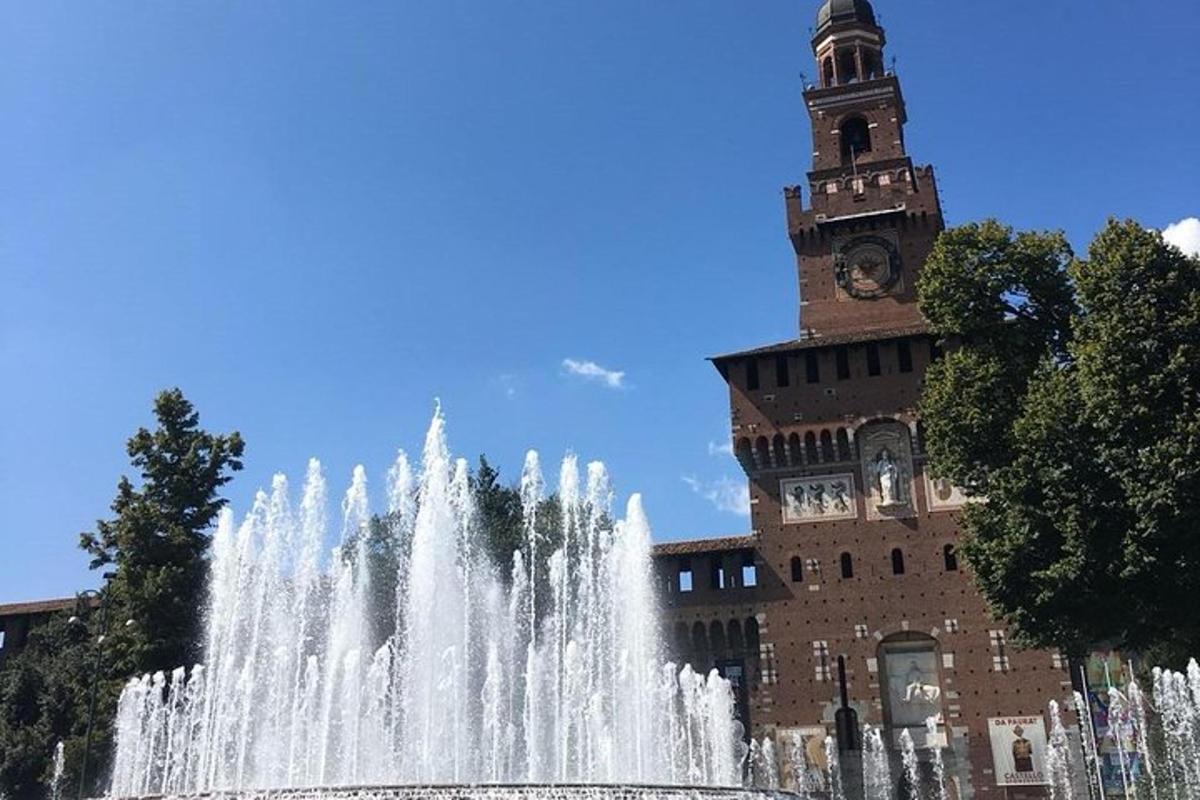 una fontana di fronte a un edificio con una torre dell'orologio