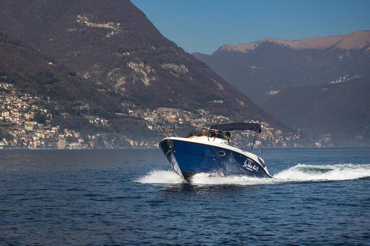 una barca blu e bianca sull'acqua con una montagna