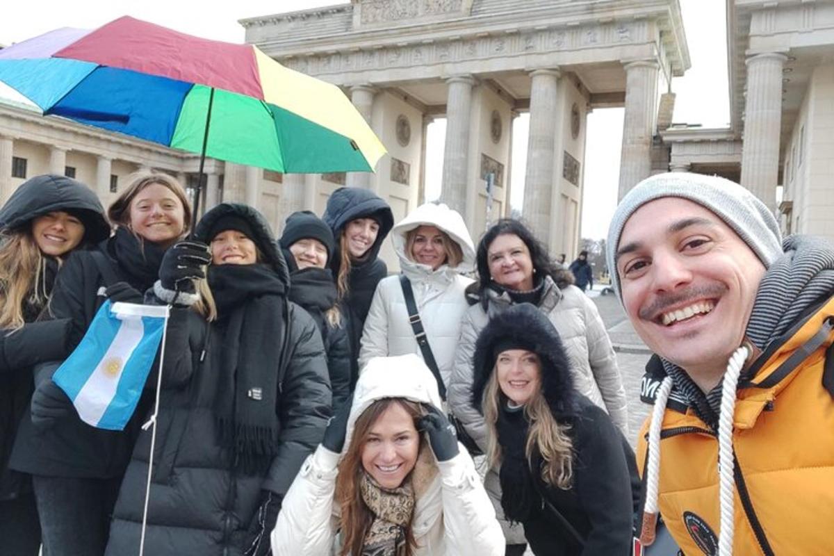 un gruppo di persone in piedi davanti a un edificio con un ombrello