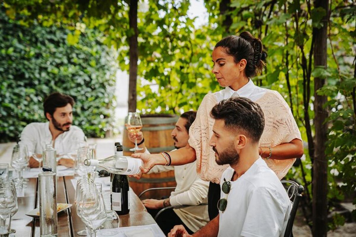 Un grupo de personas sentadas en una mesa con copas de vino.