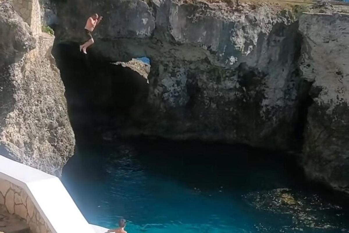 due persone che saltano in una pozza d'acqua in una grotta