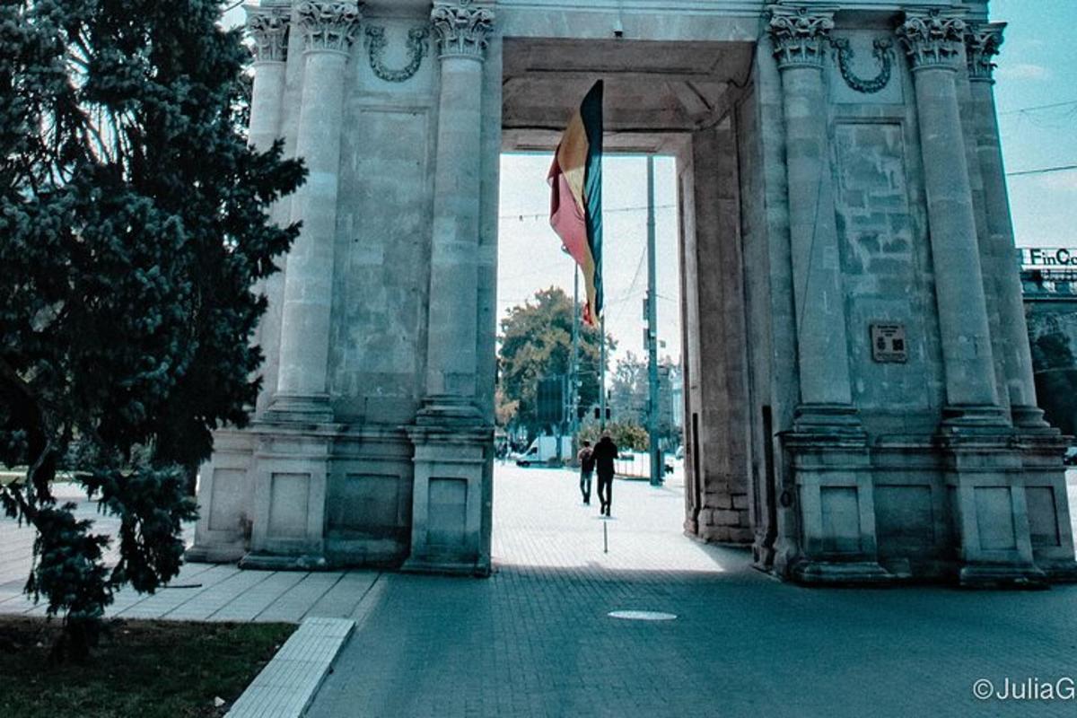 osoba jedoucí na kole pod budovou s vlajkou