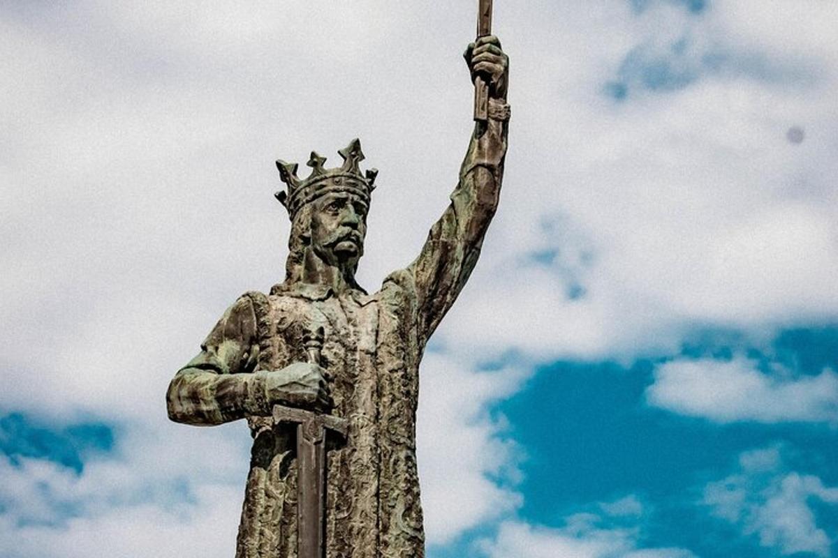 a statue of a man holding up a stick