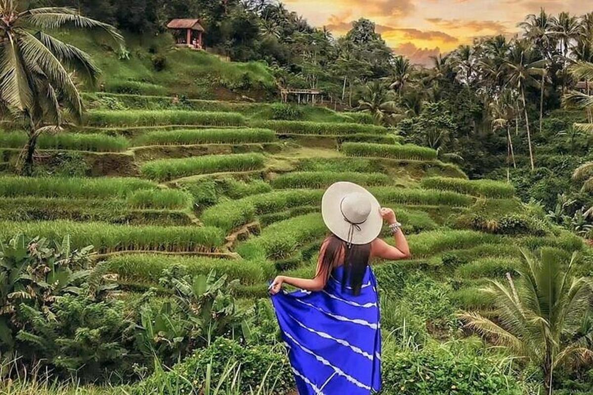 một người phụ nữ mặc váy xanh đứng trước cánh đồng