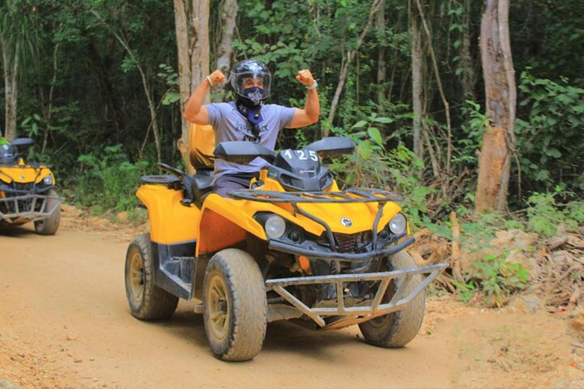 a man riding on a four wheeler on a dirt road