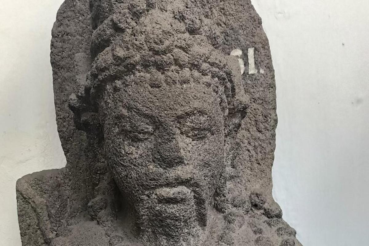 a stone statue of a head on a wall