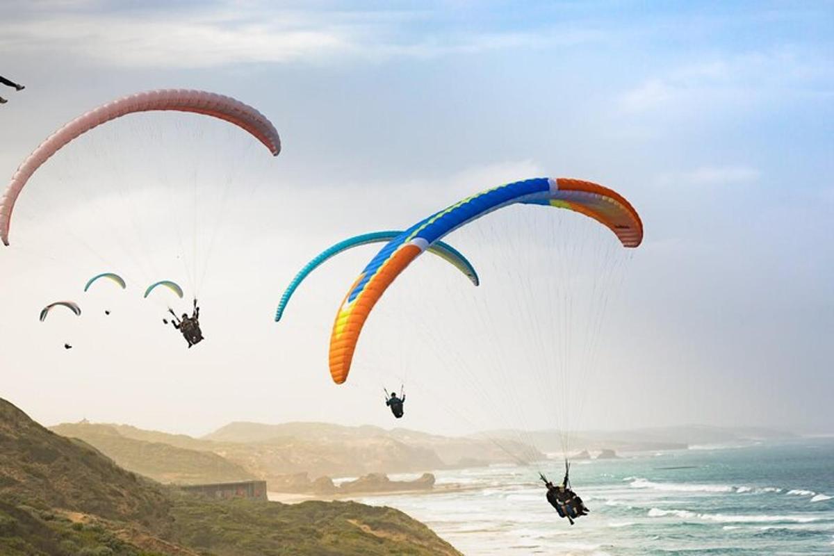 a group of people riding parachutes over the ocean