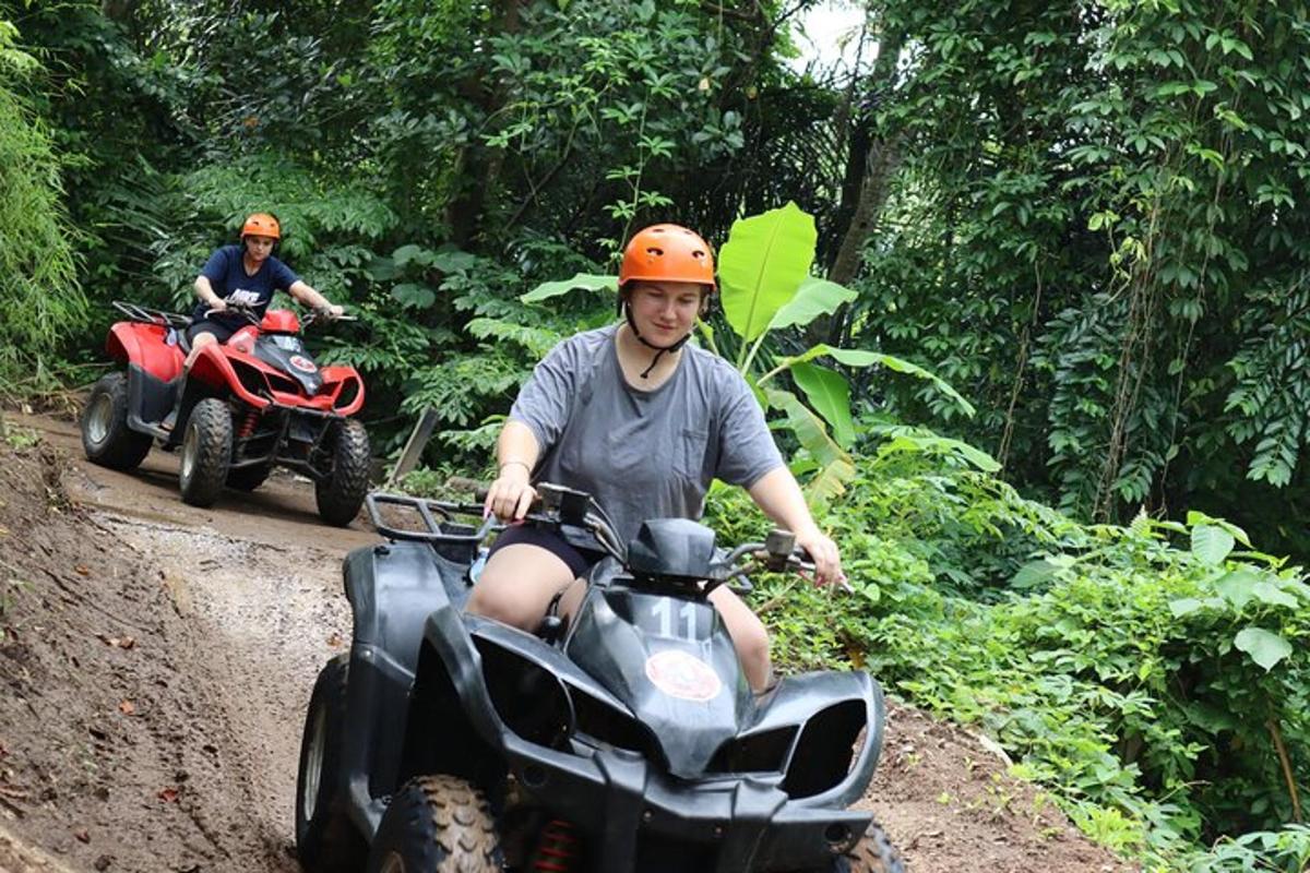 two men riding on atvs on a dirt road