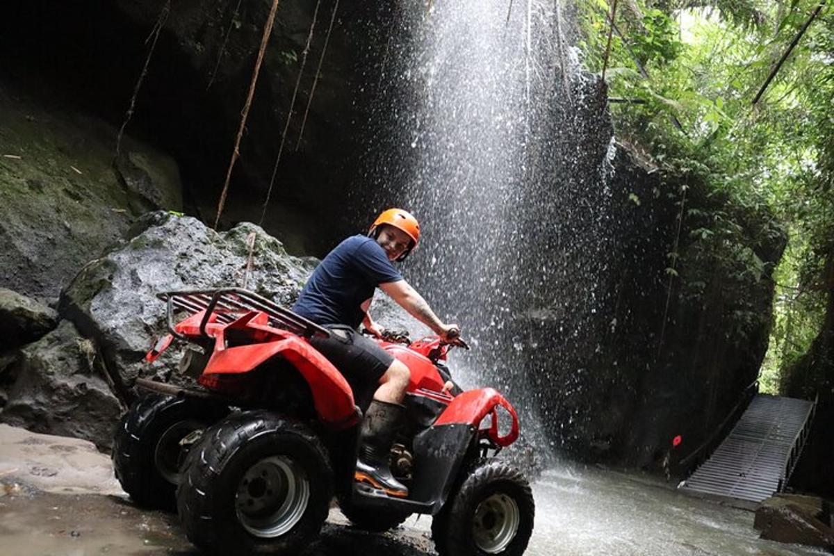 a person riding a atv in front of a waterfall